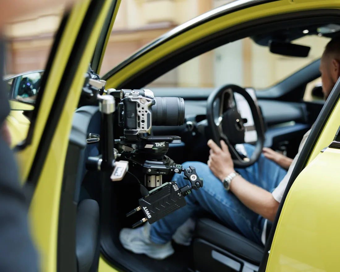 Camera rig on the open door of a yellow car