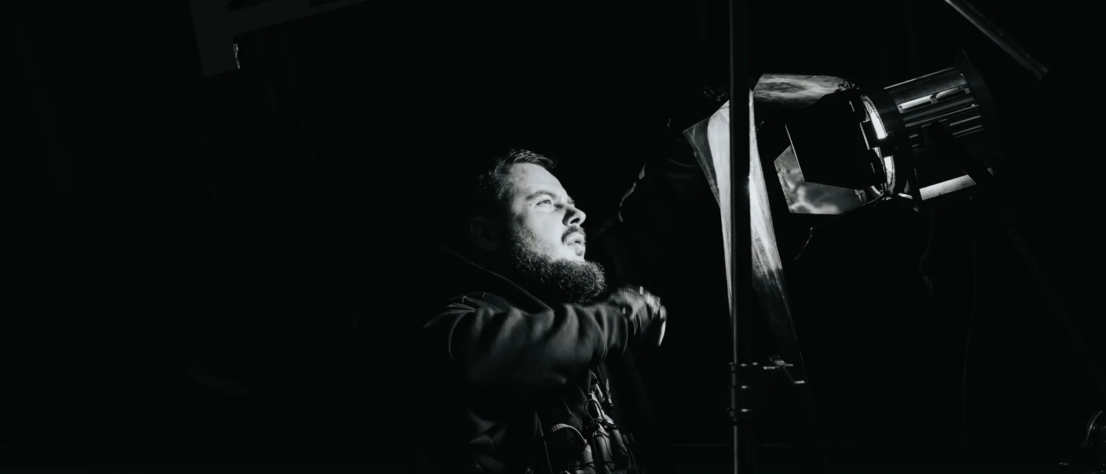 Crew member adjusting a light on set